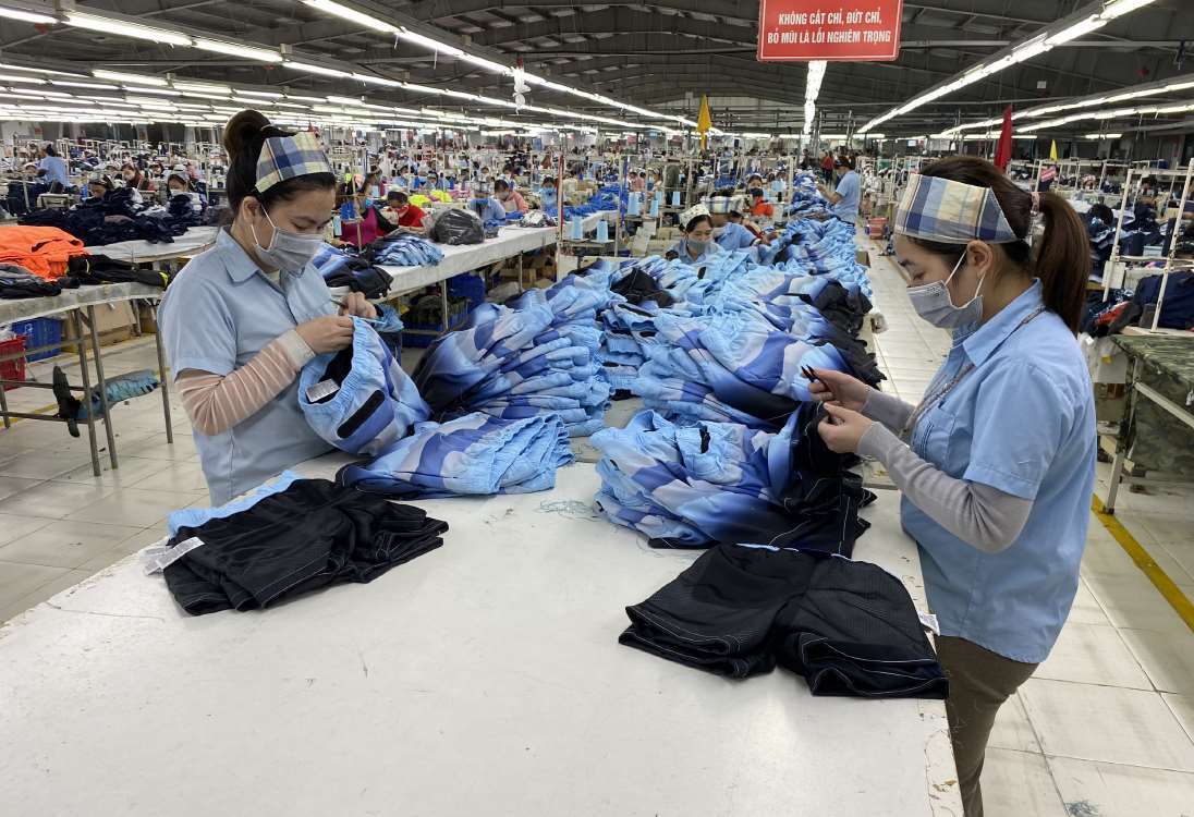 Team members working on garments inside the Hanoi factory